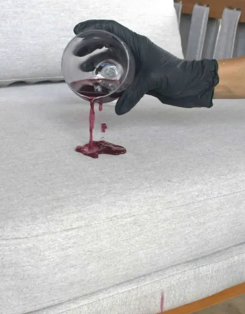 Demonstração de impermeabilização repelindo vinho sobre sofá tratado pela T&H Wash