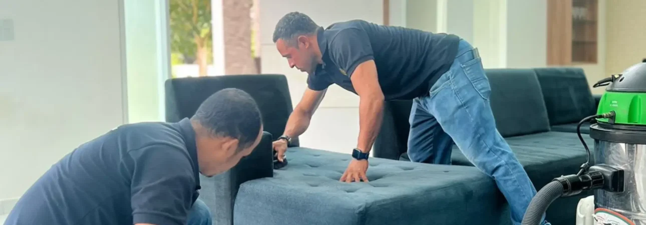 Equipe profissional de limpeza de estofados com equipamentos especializados.