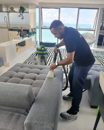 "Profissional realizando a lavagem de estofados, revitalizando o ambiente com frescor e elegante